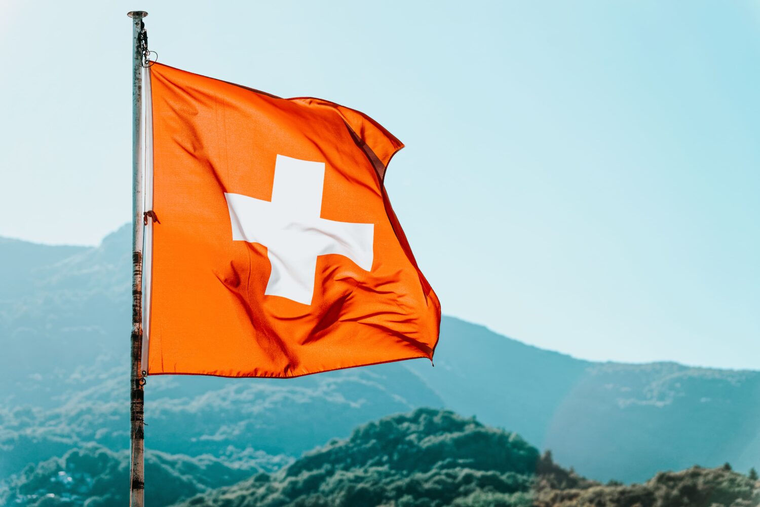 Schweizerflagge mit den Alpen im Hintergrund